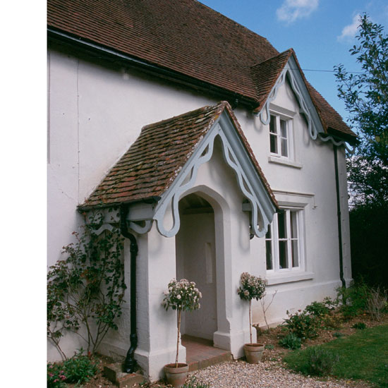 white house with red roof and plants outside