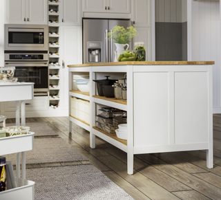 white kitchen with kitchen island storage, wine rack, wooden floors