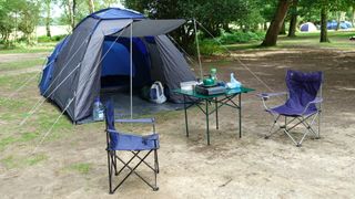 Camping table and two chairs outside tent