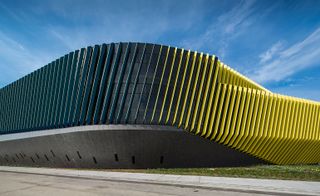El Centro building composed of a rhythmic, boldly coloured pattern of sunshades, metal panels, and mirrored glass
