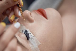 Closeup of woman getting eyelash extensions application
