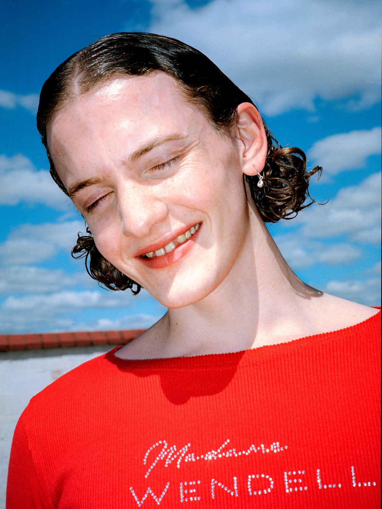 Model wearing red top, close-up, with sequin logo Madama Wendell