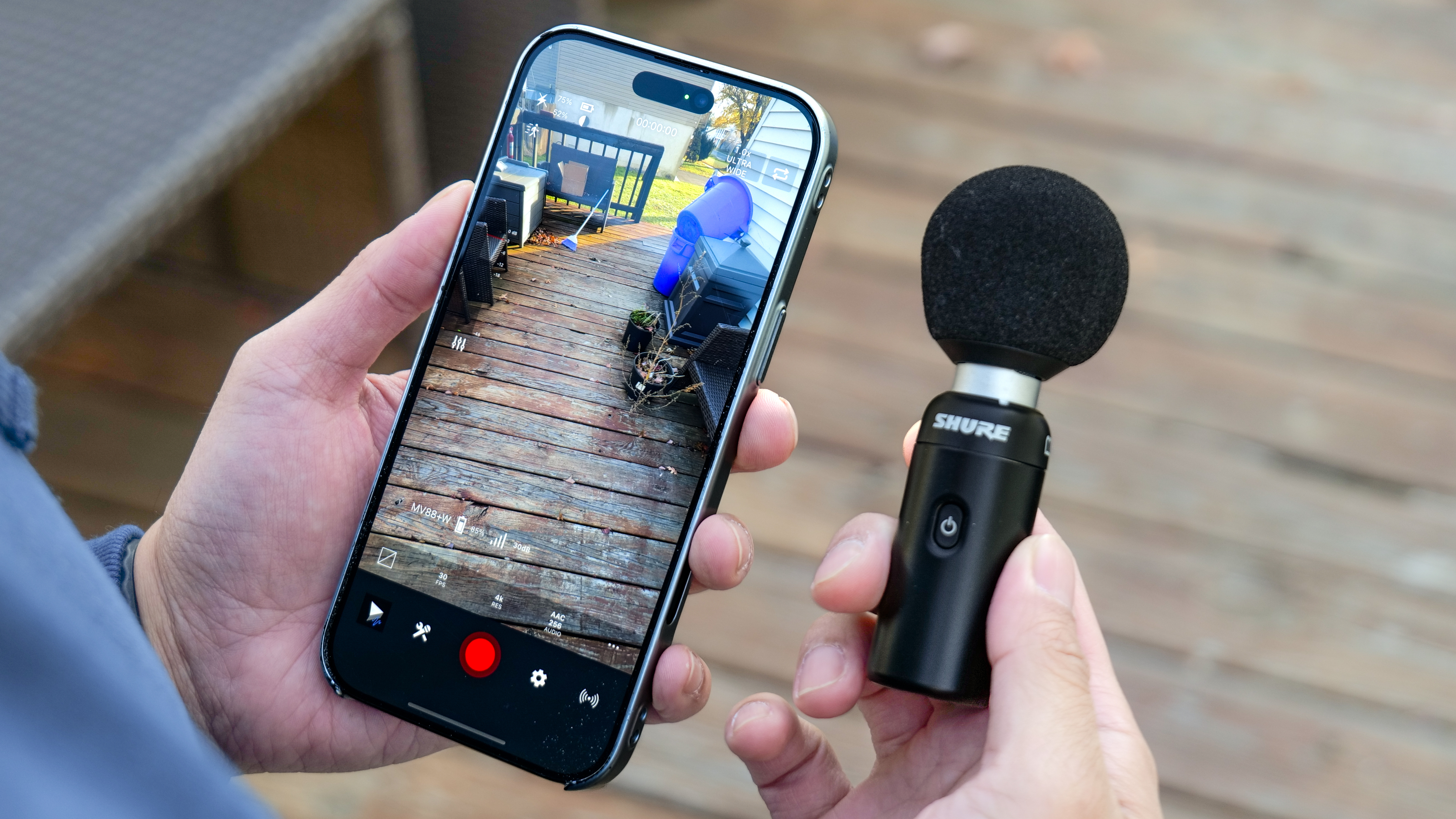 Shure MoveMic 88+ held in the hand with Motiv app running on an iPhone.