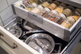 A kitchen drawer arranged with jars of spices