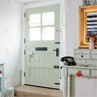 white wall with front door and telephone