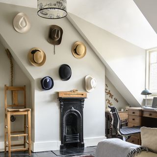 room with white wall and hats on walls and fireplace and chairs