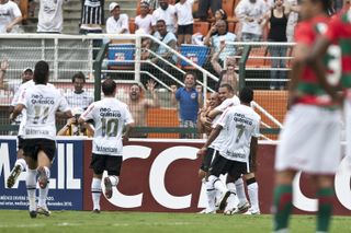 Roberto Carlos celebrates with Corithinians team-mates after scoring directly from a corner against Portuguesa in January 2011.