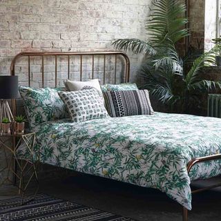 bedroom with leafy bed and potted plant