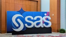 A photo of the SAS logo on a 3D standee at SAS Innovate 2025 held at the Hilton Orlando. The white text is set against a stylized blue background with a pink stripe to the right.