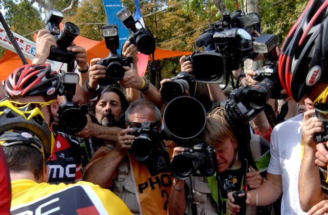 BMC's Cadel Evans celebrates in front of a wall of journalists after winning the 2011 Tour's general classification on the Champs Elys&eacute;es.