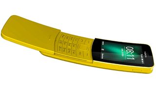 A yellow Nokia 8110 phone against a white background - one the best burner phones