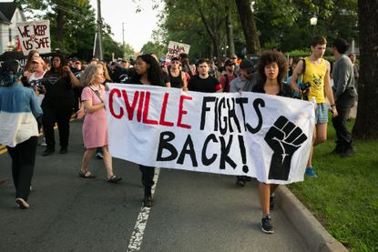 Demonstrators march down Rugby Avenue near the University of Virginia campus one-year after the violent white nationalist rally that left one person dead and dozens injured, in Charlottesvill