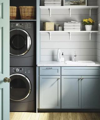 white sterling sink laundry room blue cabinets grey washing machine and tumble dryer