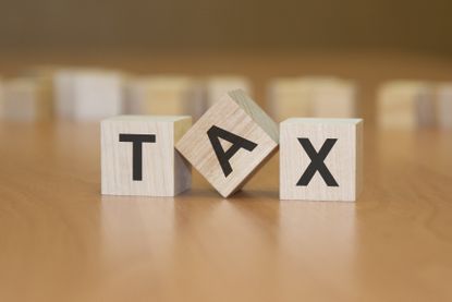 the word tax on three blocks with the A tilted