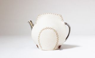 Silver teapot with white felt cover