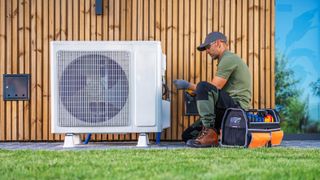 Technician repairing HVAC unit outside