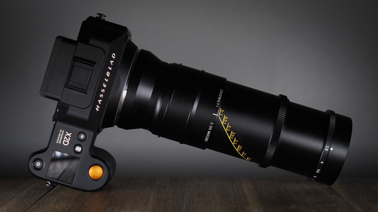 Mitakon 55mm f/2.8 1-5x Macro mounted to. a Hasselblad X2D, on a wooden surface