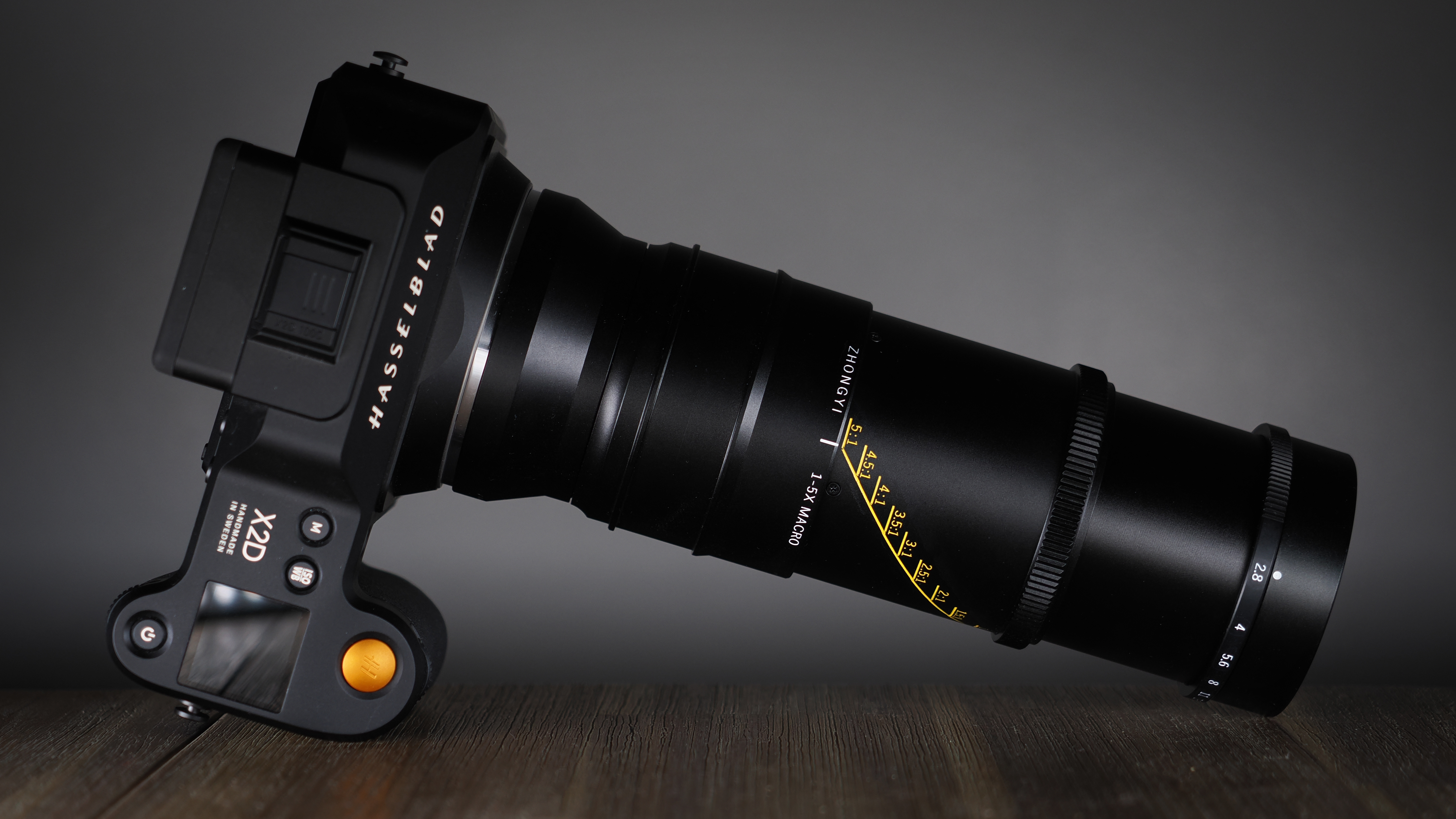 Mitakon 55mm f/2.8 1-5x Macro mounted to. a Hasselblad X2D, on a wooden surface