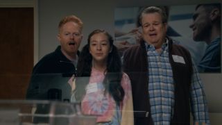 Mitch, Lily, and Cam in the maternity ward at the hospital looking at the new baby.