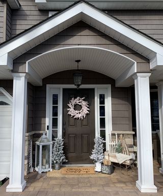 Christmas porch decor with neutral color scheme white wreath and snowy trees