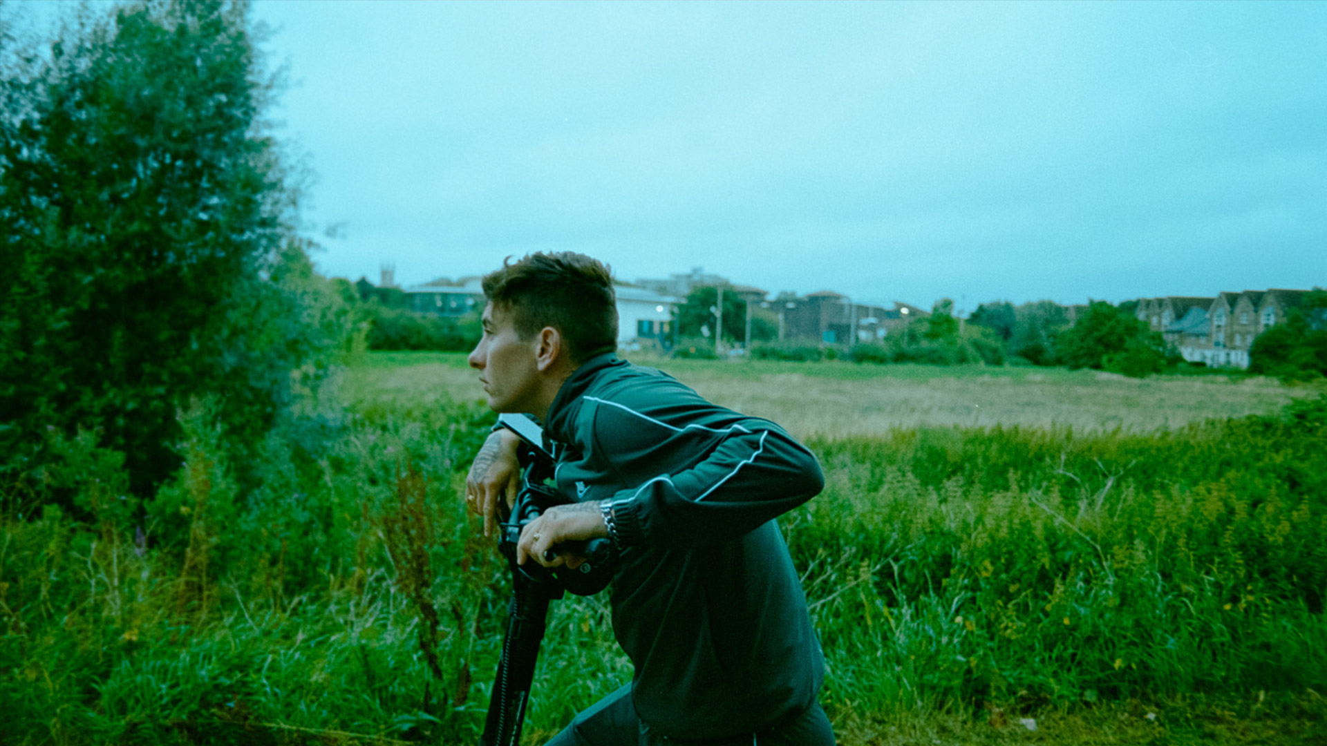 Barry Keoghan rides a bike next to a field in the movie Bird