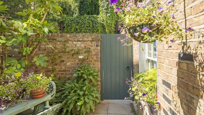 garden gate ideas showing a painted wooden garden gate in a stone wall