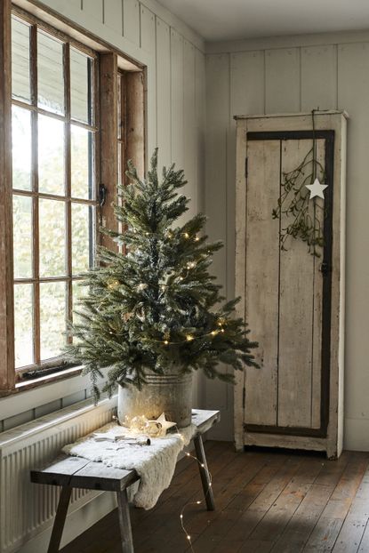 Small Christmas tree on console table by Neptune