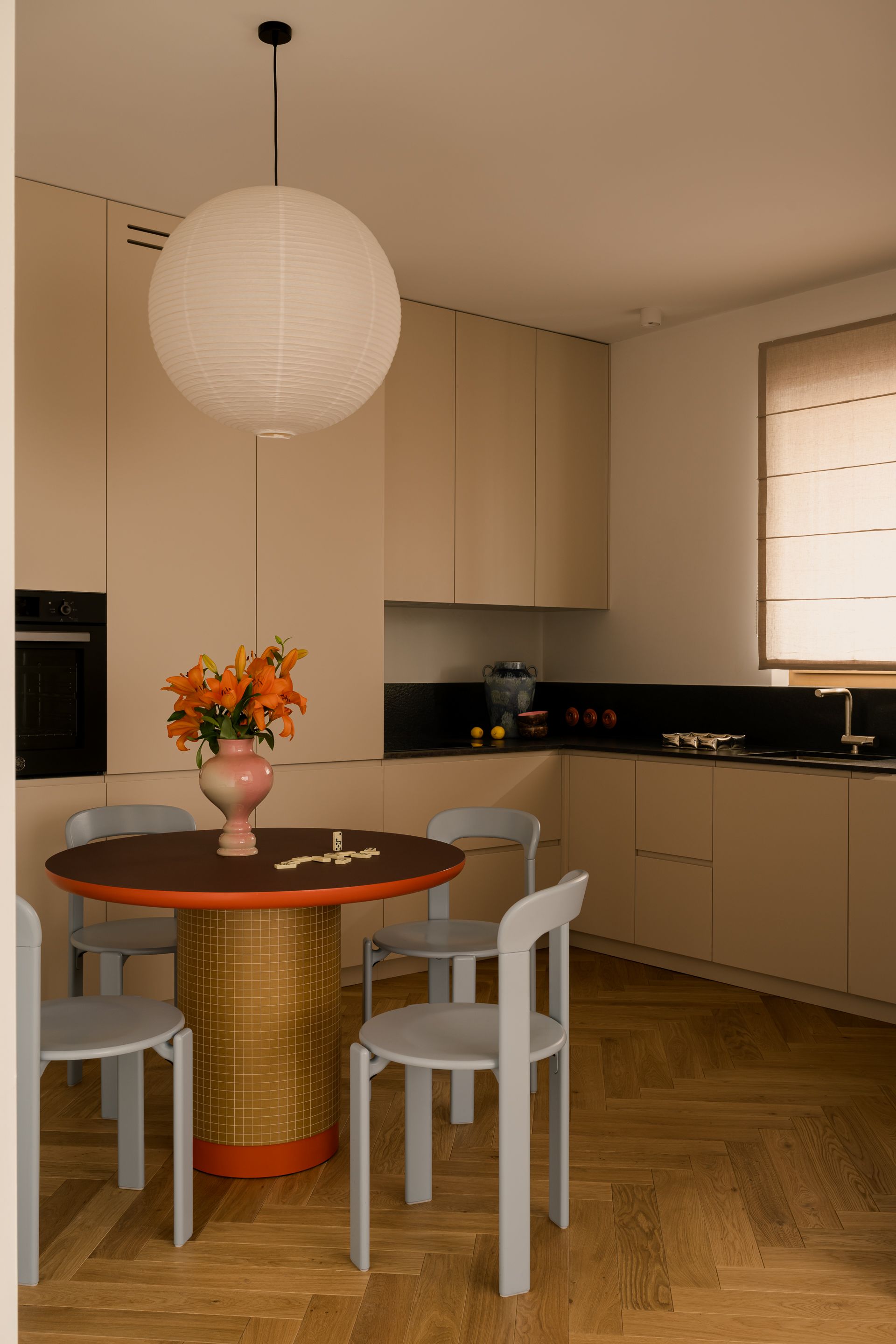 A neutral kitchen with red and blue furniture