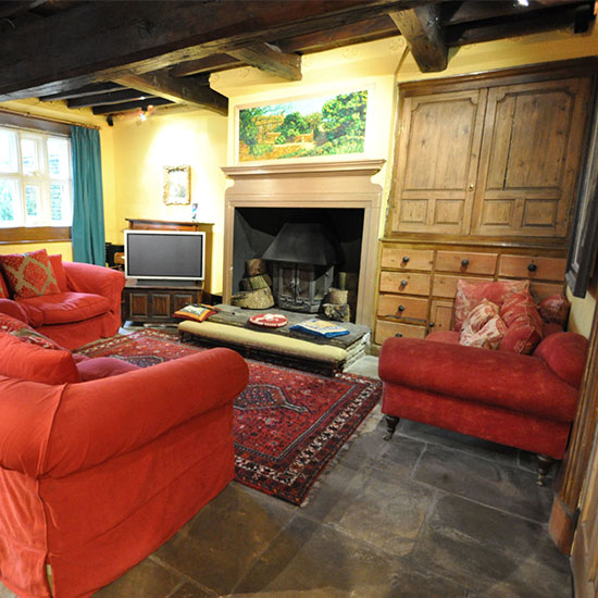 living room with red sofa wooden cupboard and drawer and television