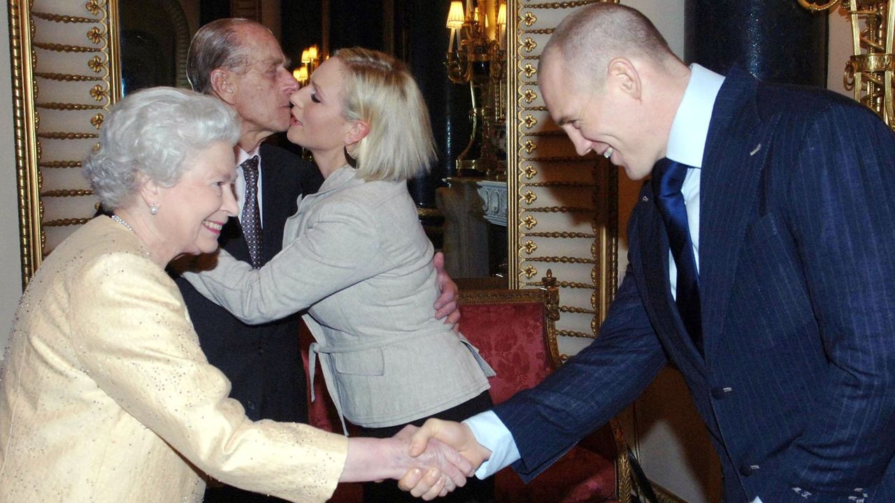 Prince Philip, Duke of Edinburgh kisses his granddaughter, Zara Phillips, as boyfriend, English rugby player Mike Tindall, shakes hands with Queen Elizabeth ll at a Buckingham Palace reception for the country&#039;s top achievers on December19, 2006 in London, England. 