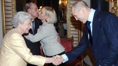 Prince Philip, Duke of Edinburgh kisses his granddaughter, Zara Phillips, as boyfriend, English rugby player Mike Tindall, shakes hands with Queen Elizabeth ll at a Buckingham Palace reception for the country's top achievers on December19, 2006 in London, England. 