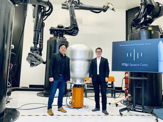 Mu Space CEO & Founder James Yenbamroong (left) and Relativity Space CEO & Founder Tim Ellis (right) stand in front of Relativity's Stargate, the world's largest metal 3D printer. 