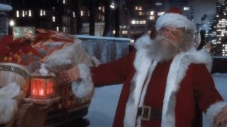 David Huddleston as Santa next to his sleigh in Santa Claus: The Movie