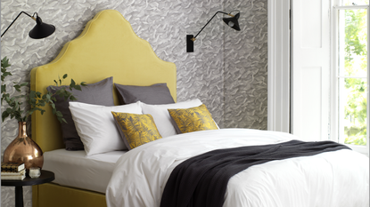 bedroom with yellow headboard and grey wallpaper 