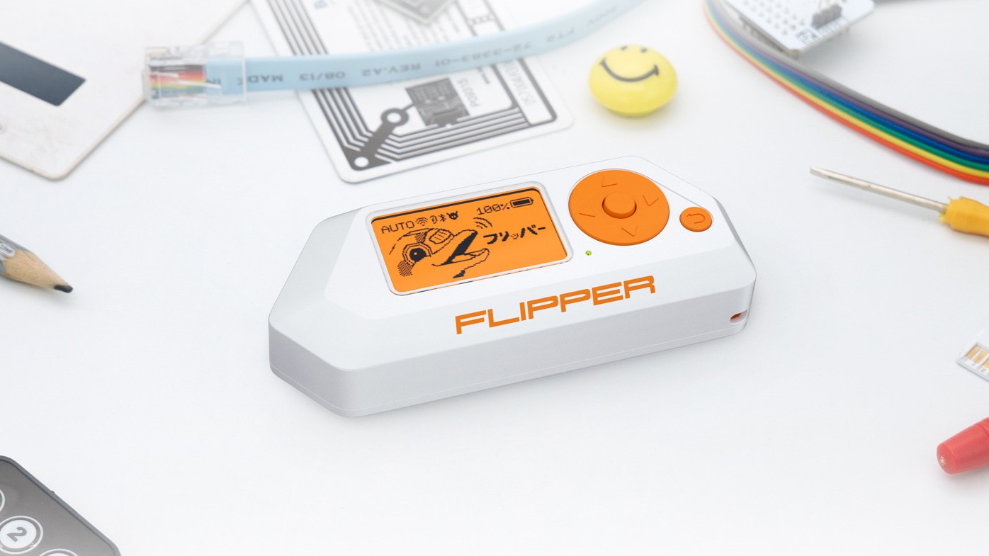 Ein Flipper Zero-Pentesting-Tool auf einem Tisch mit anderen Gadgets