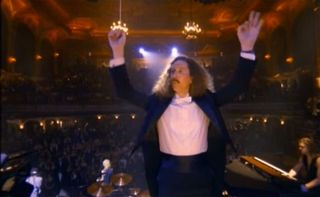A still from the November Rain video showing a man conducting an orchestra