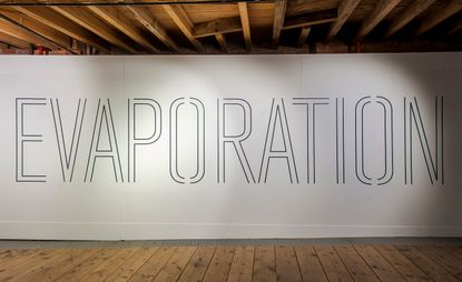 An art installation in the Manchester Museum of Science and Industry. 'Evaporation' is written in all caps on a white board.