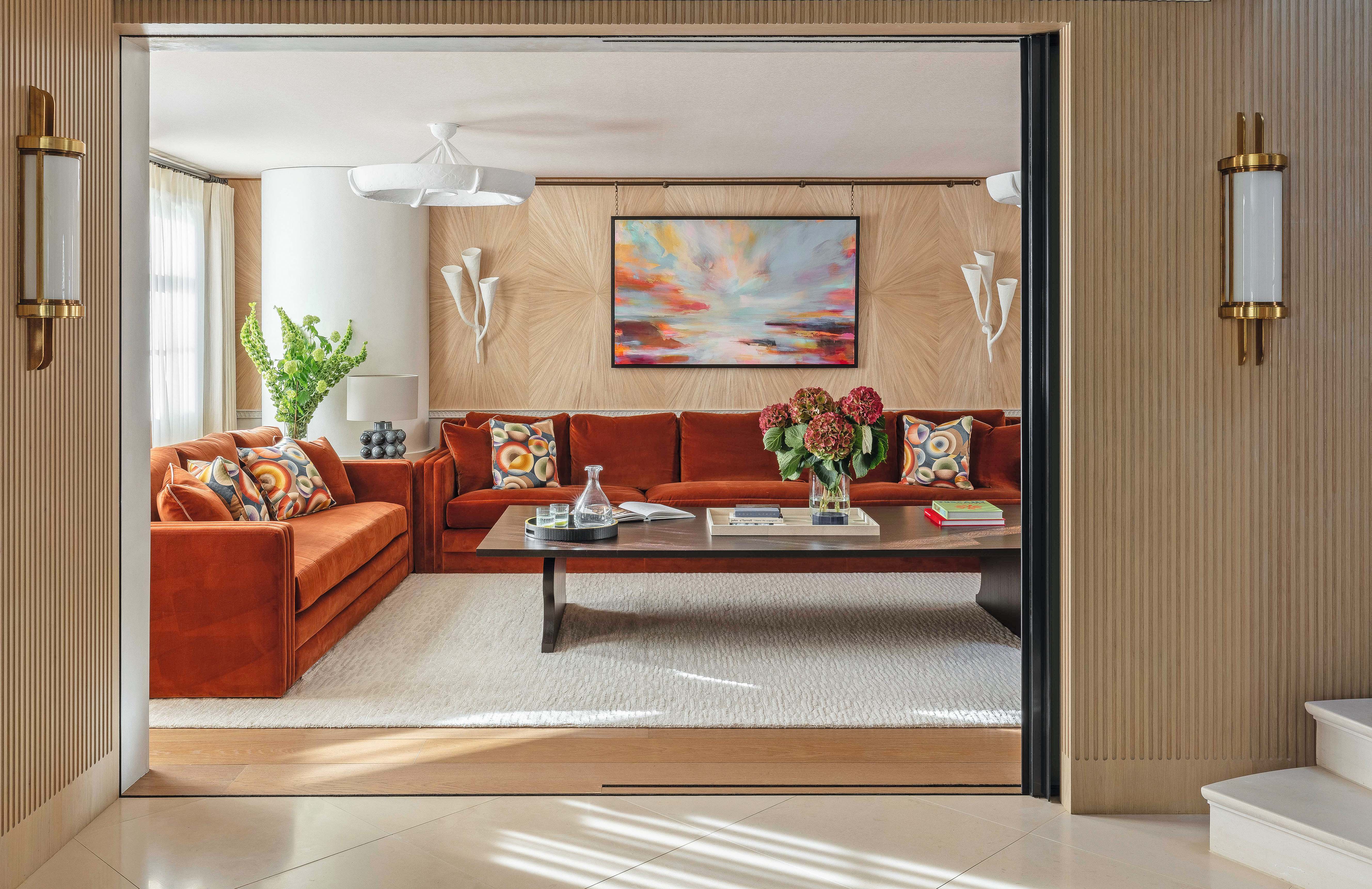 Modern living room with wooden clad walls and orange sofa