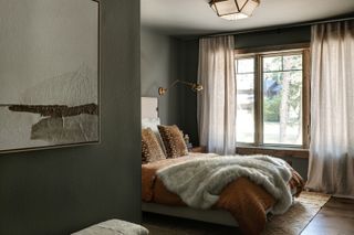 A bedroom with teal walls and taupe bedding