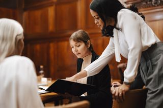 Legal professionals discuss a case in a courtroom 