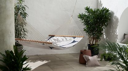 best hammock: a black and white hammock hanging in a contemporary outdoor courtyard