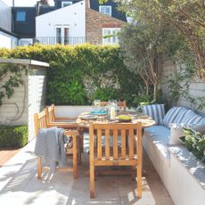 A garden seating area with outdoor wooden furniture