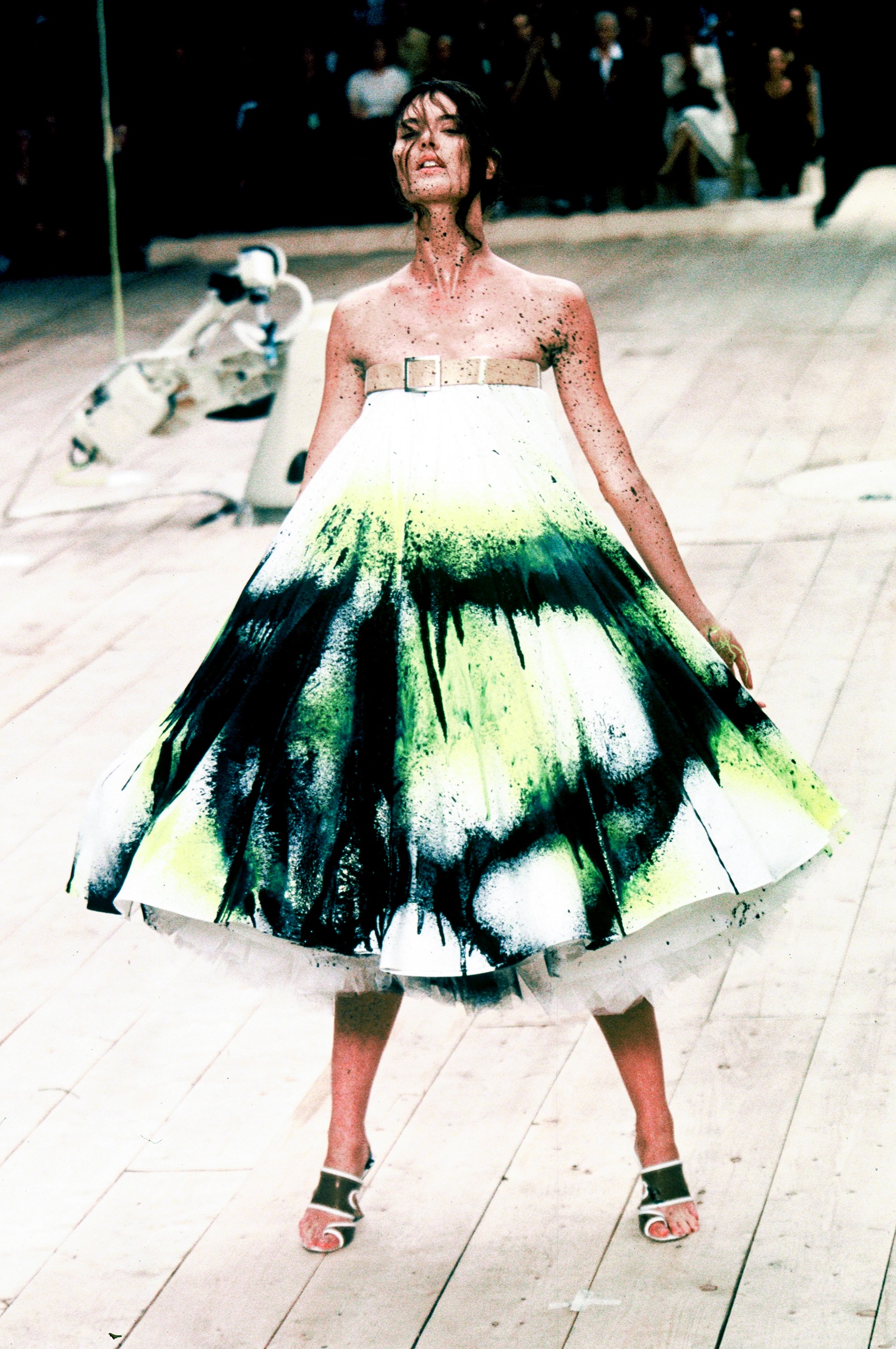 Shalom Harlow is sprayed with paint by robots on the runway during an Alexander McQueen show