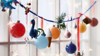 IKEA Christmas baubles hanging on a string in front of a window