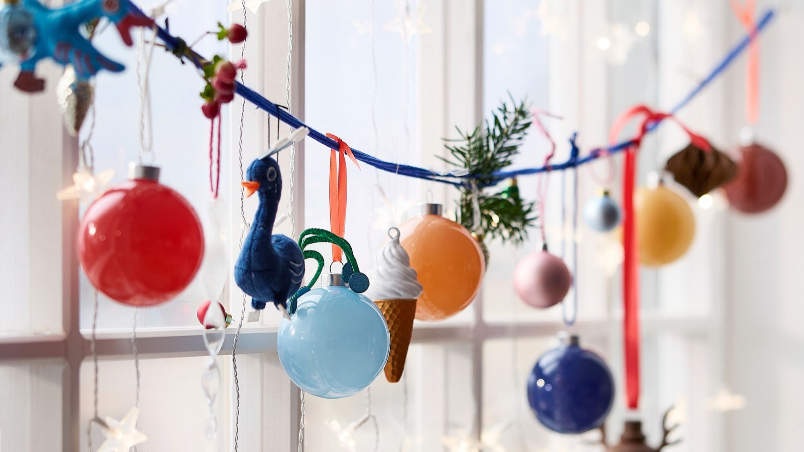 IKEA Christmas baubles hanging on a string in front of a window