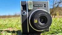 En Fujifilm Instax Mini 40-kamera på en gräsmatta.