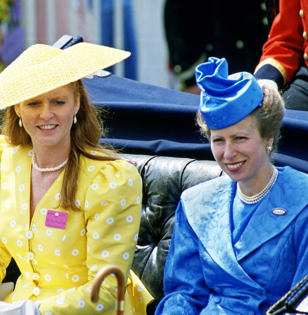 Princess Anne in a blue coat and Sarah Ferguson in a yellow dress and hat riding in a carriage at Royal Ascot 1987