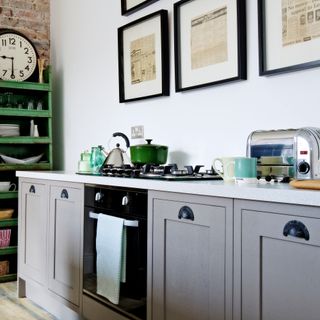Kitchen with grey cabinetry and green open storage unit