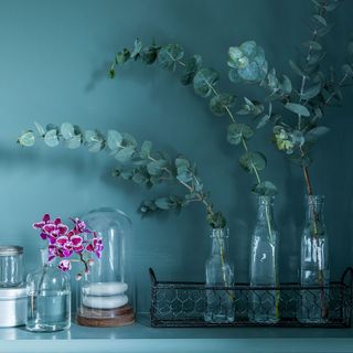 bathroom with dark green walls and glass flower vase
