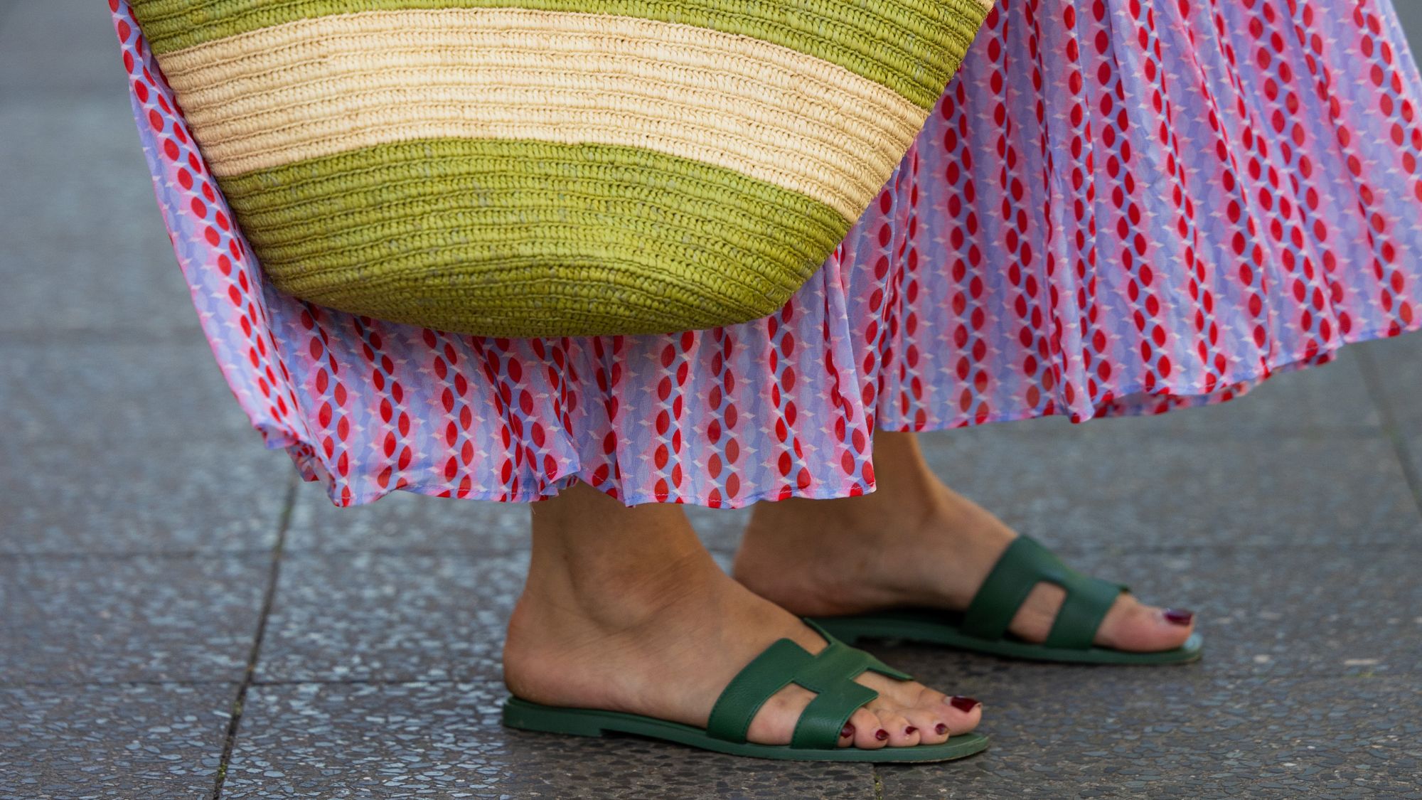 a close up of a woman's sandals with painted dark red toes